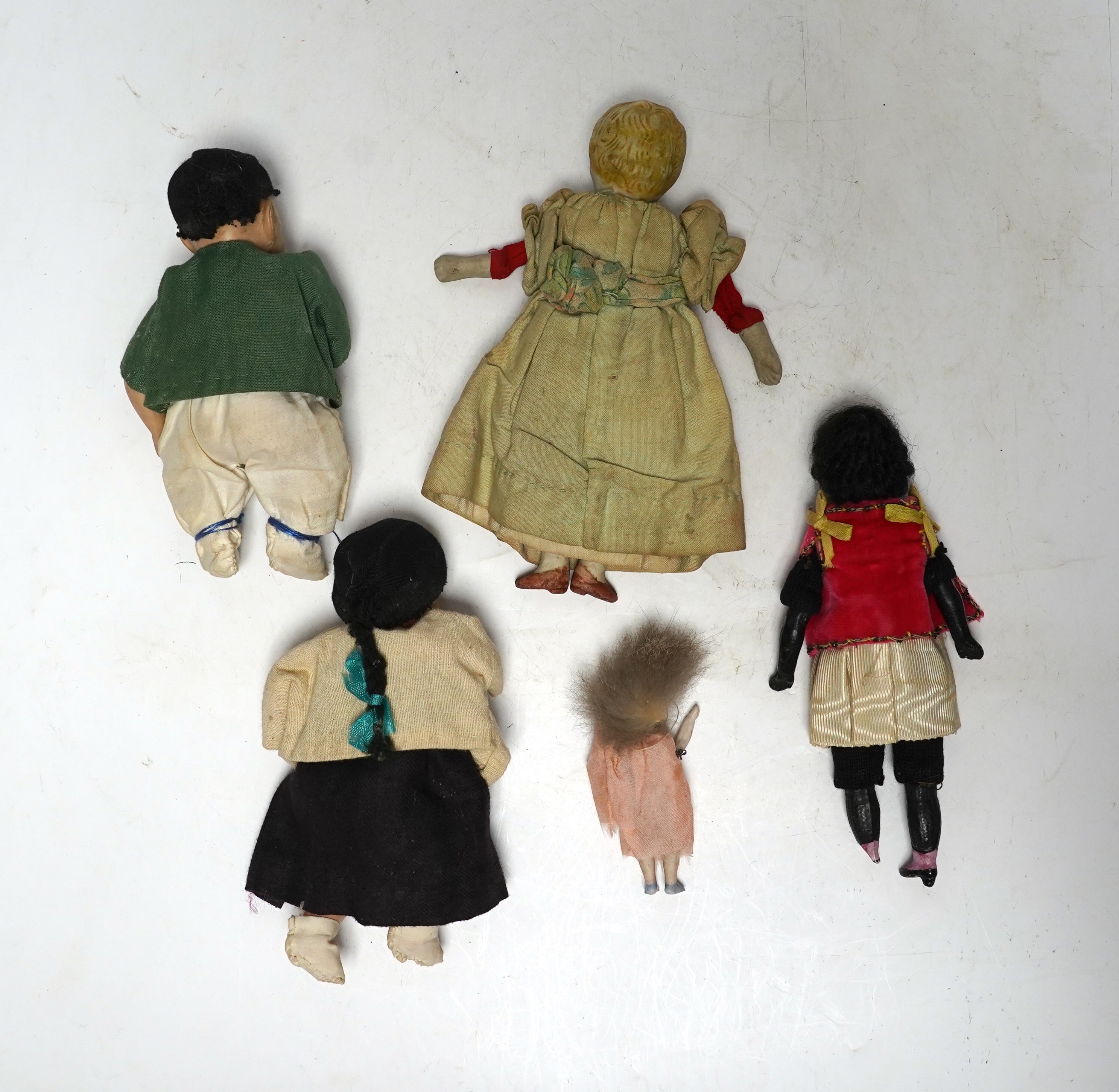 Five various small world dolls, two celluloid and three bisque/china, largest 15cm high